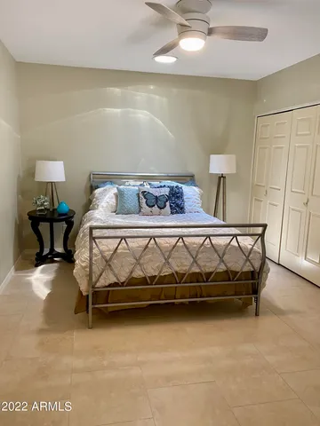 a bed sitting in a room next to a lamp