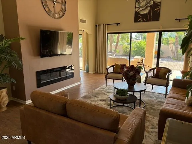 a living room with furniture a flat screen tv and a large window