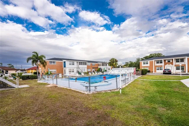 a view of a house with a big yard and sitting area