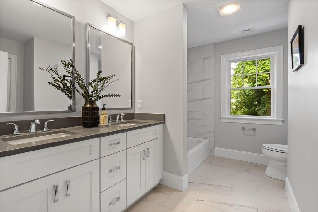 31 Kenilworth Road Arlington, MA 02476 - Photo 30 of 41 a bathroom with a granite countertop sink a toilet a mirror and window
