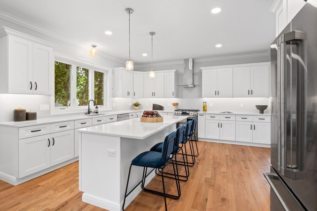 31 Kenilworth Road Arlington, MA 02476 - Photo 3 of 41 a kitchen with stainless steel appliances kitchen island wooden floors and white cabinets