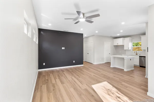 a view of a kitchen with wooden floor and a ceiling fan