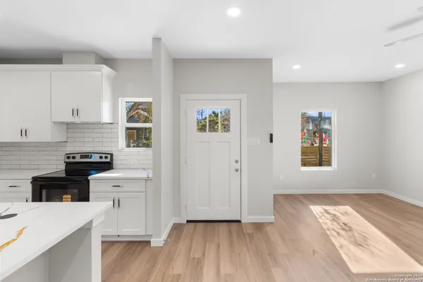 a kitchen with granite countertop white cabinets and black appliances