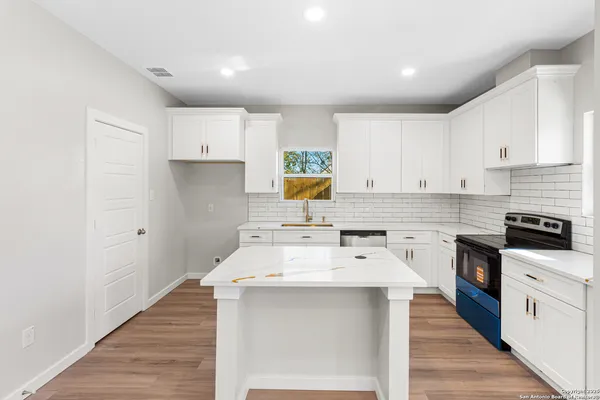 a kitchen with a sink stove and cabinets