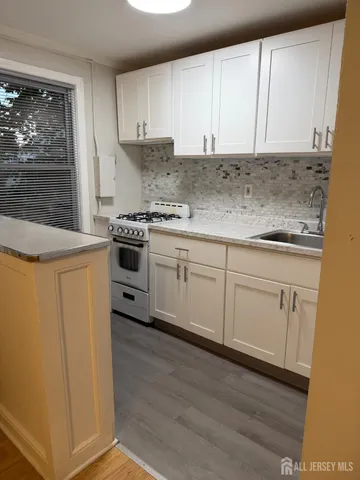 a kitchen with granite countertop white cabinets and white appliances