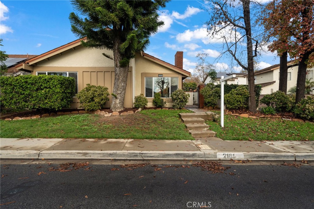 2181 Maple Court Tustin, CA 92780 - Photo 27 of 29 a front view of a house with a yard and potted plants