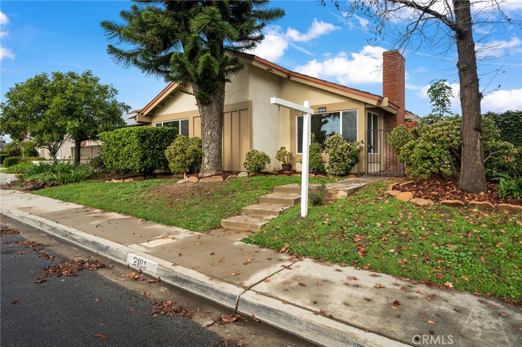 2181 Maple Court Tustin, CA 92780 - Photo 4 of 29 a front view of a house with a yard and potted plants