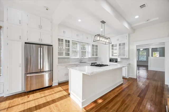 a kitchen with stainless steel appliances granite countertop a refrigerator a stove a sink dishwasher and a refrigerator with wooden floor