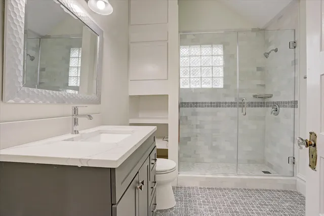 a bathroom with a sink a toilet and shower