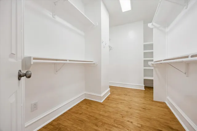 a view of walk in closet with wooden floor