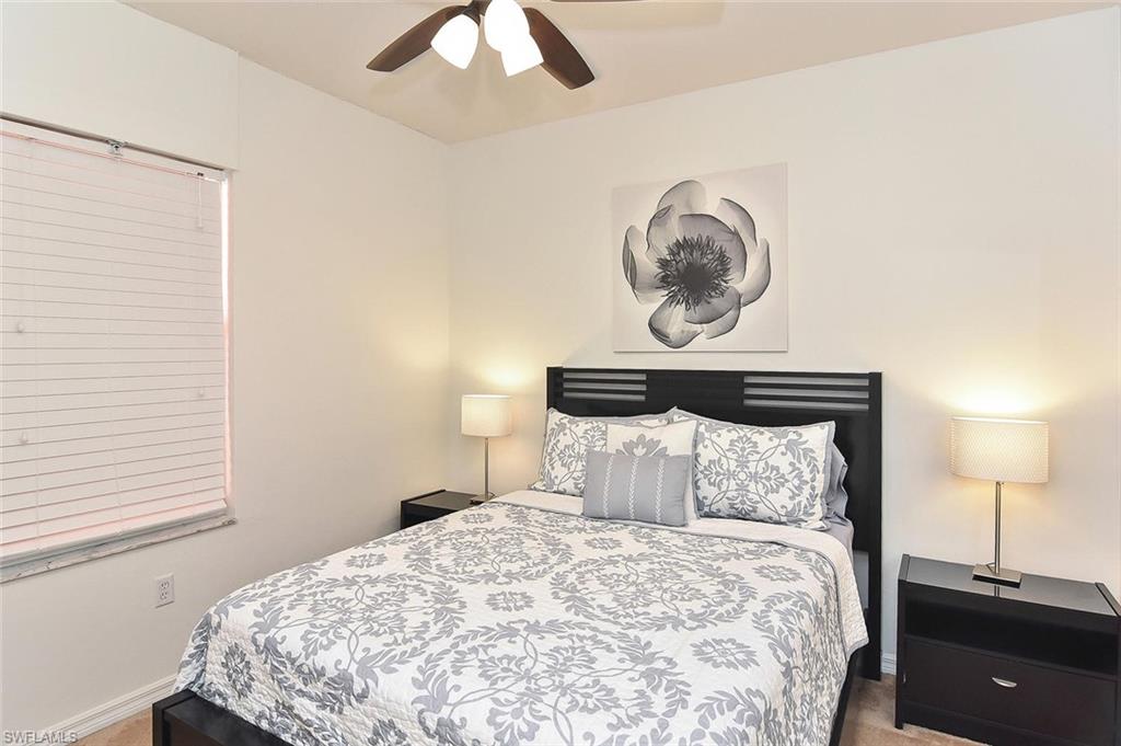 519 Roma Court, Unit 3208 Naples, FL 34110 - Photo 20 of 22 a bedroom with a bed and a lamp
