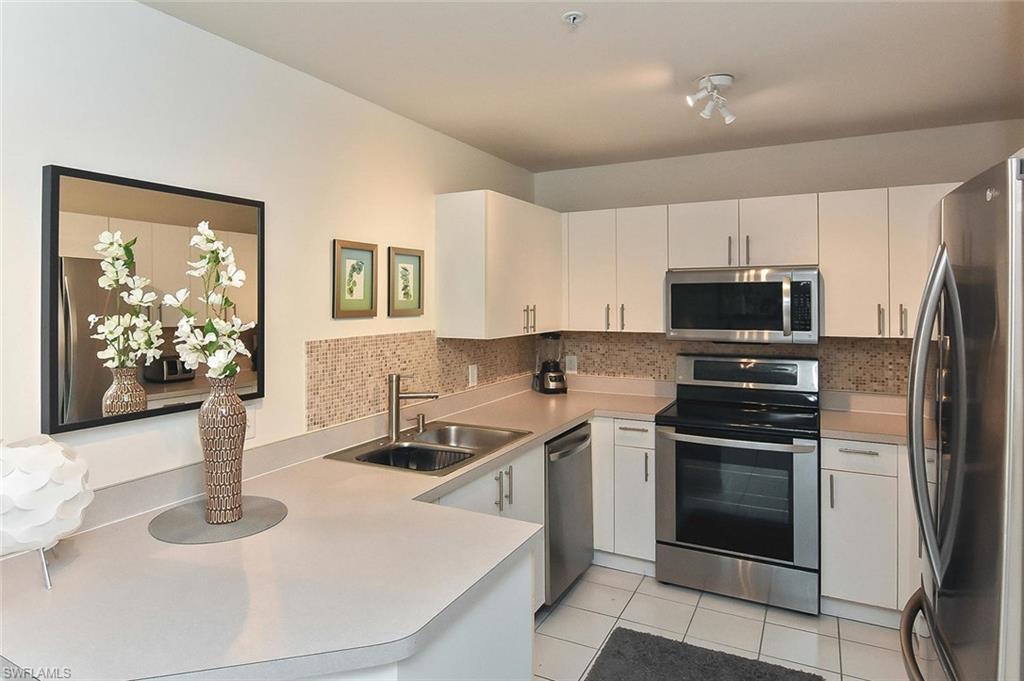 519 Roma Court, Unit 3208 Naples, FL 34110 - Photo 3 of 22 a kitchen with stainless steel appliances granite countertop a sink stove and microwave