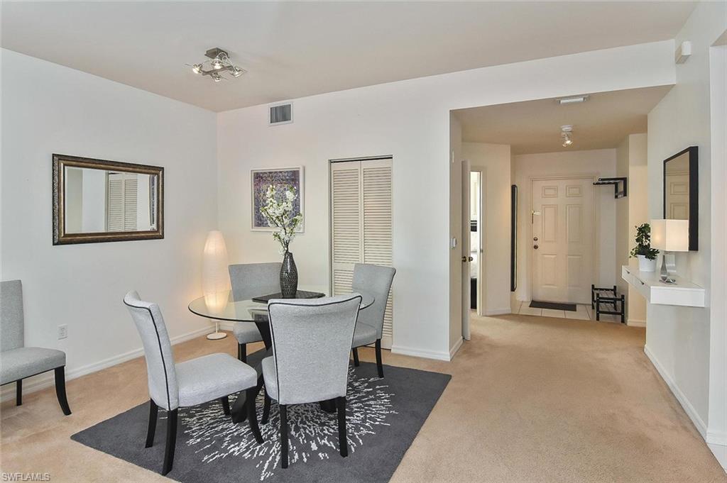 519 Roma Court, Unit 3208 Naples, FL 34110 - Photo 6 of 22 a view of a dining room with furniture and wooden floor