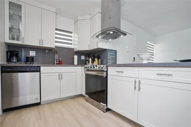 a kitchen with white cabinets stainless steel appliances and sink