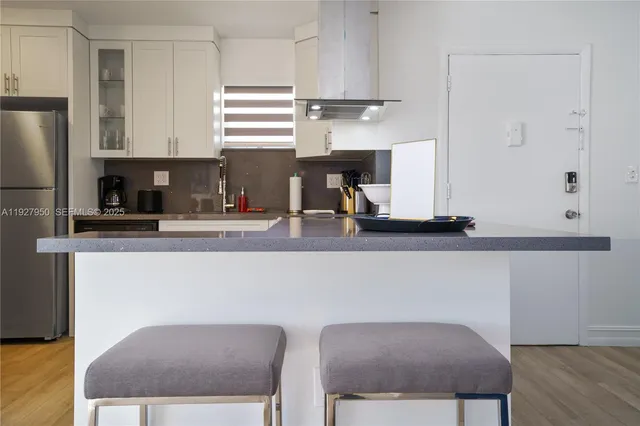 a kitchen with a table chairs refrigerator and cabinets