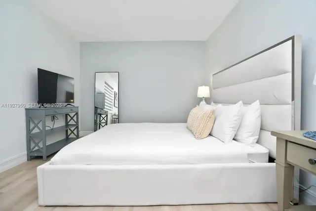 a bedroom with a bed and a flat screen tv