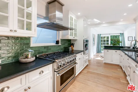 a kitchen with stainless steel appliances kitchen island granite countertop a sink and cabinets