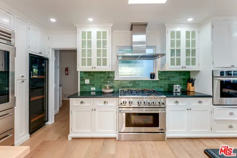 a large white kitchen with granite countertop lots of counter top space