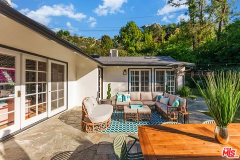 a view of a backyard with sitting area and garden