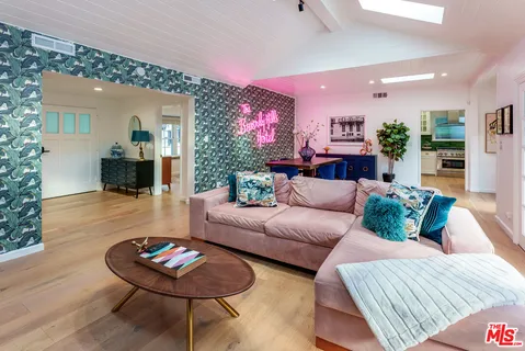 a living room with furniture a flat screen tv and a floor to ceiling window