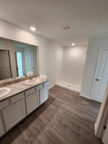 a bathroom with double vanity sink and a mirror