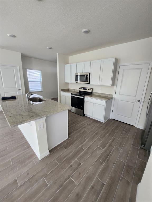 5149 Southwest 48th Lane Gainesville, FL 32608 - Photo 15 of 16 a kitchen with a sink cabinets and wooden floor