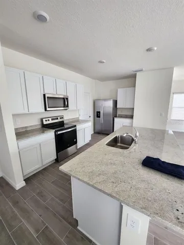 a kitchen with microwave a stove and cabinets