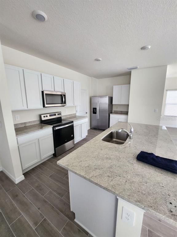 5149 Southwest 48th Lane Gainesville, FL 32608 - Photo 5 of 16 a kitchen with microwave a stove and cabinets
