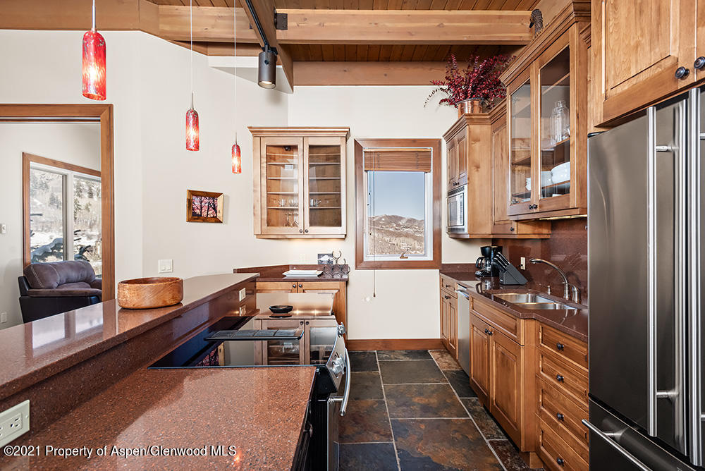 800 Ridge Road, Unit 13 Snowmass Village, CO 81615 - Photo 3 of 23 a kitchen with stainless steel appliances granite countertop a stove a refrigerator and a cabinets