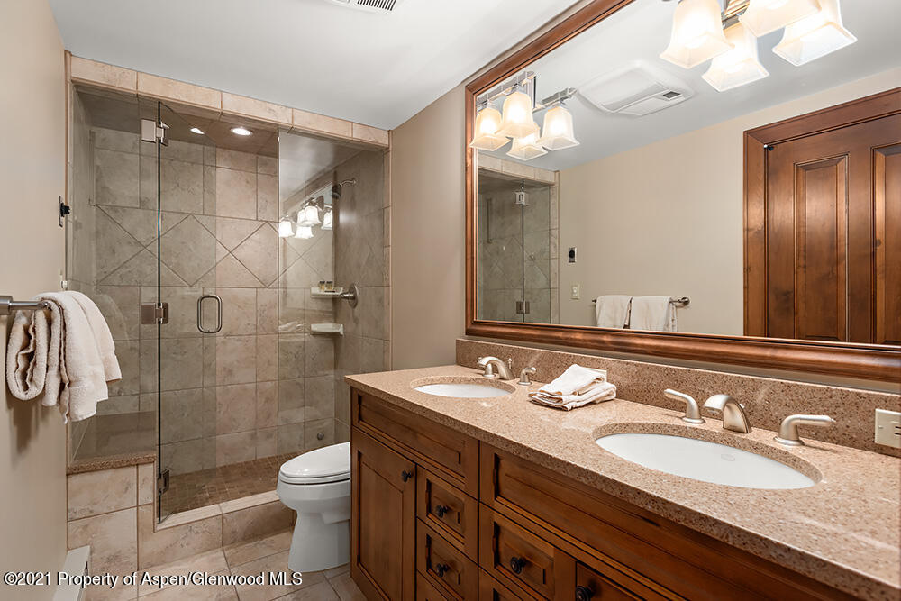 800 Ridge Road, Unit 13 Snowmass Village, CO 81615 - Photo 10 of 23 a bathroom with a granite countertop double vanity sink toilet and shower