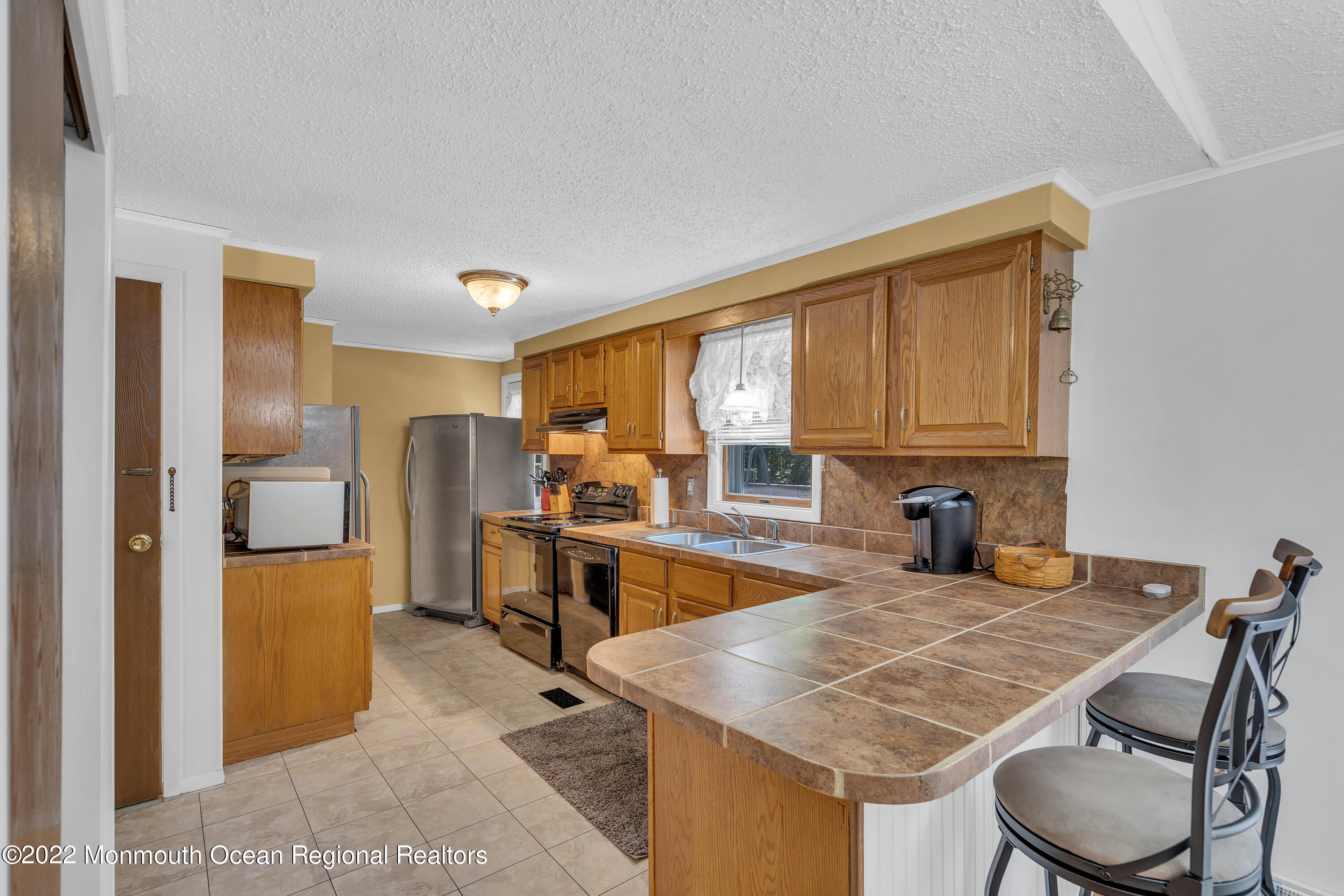 356 Cedar Swamp Road Jackson, NJ 08527 - Photo 15 of 56 a kitchen with a table chairs refrigerator and cabinets