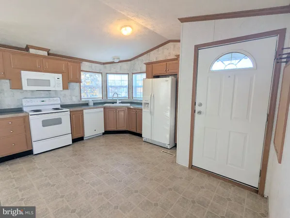 a large kitchen with a stove a refrigerator and a sink