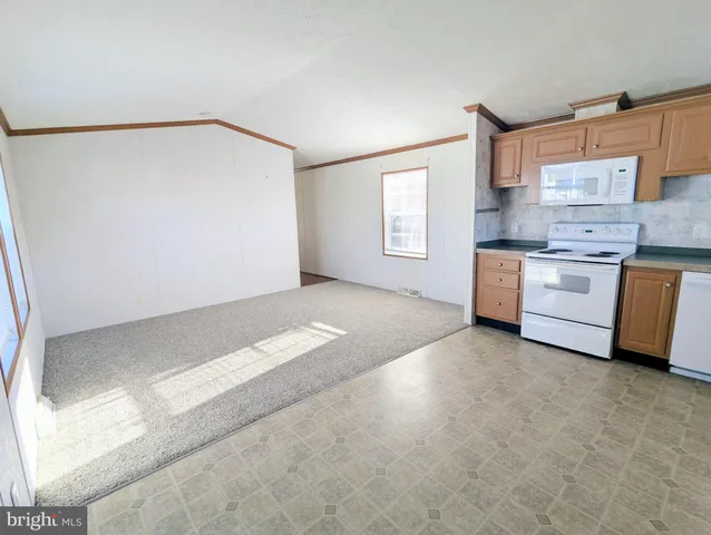 a view of a kitchen with a sink a stove top oven and white cabinets