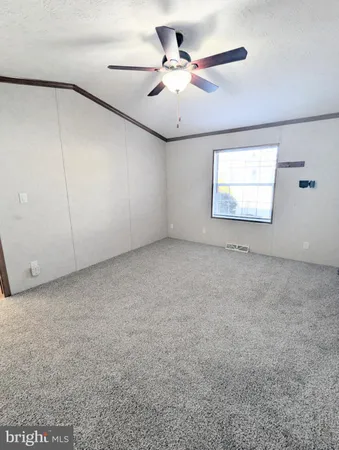 an empty room with windows and ceiling fan
