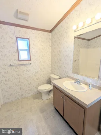 a bathroom with a granite countertop sink a toilet and a mirror