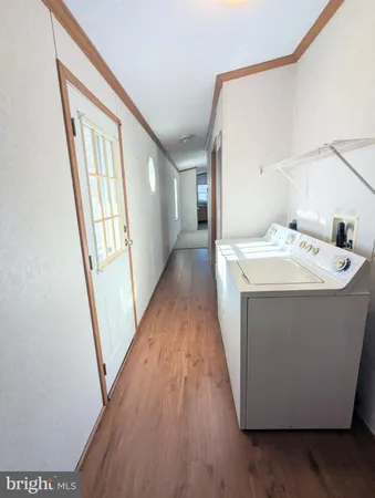 a utility room with wooden floor washer and dryer