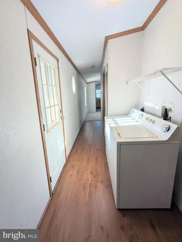 a utility room with wooden floor washer and dryer