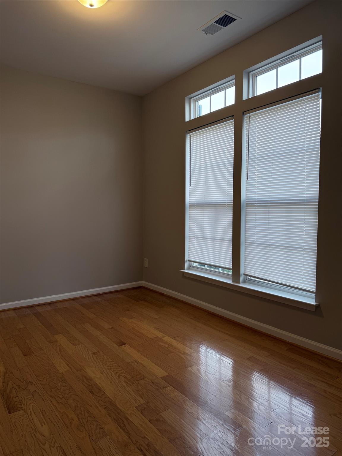 4968 Prosperity Ridge Road Charlotte, NC 28269 - Photo 4 of 19 an empty room with wooden floor and windows