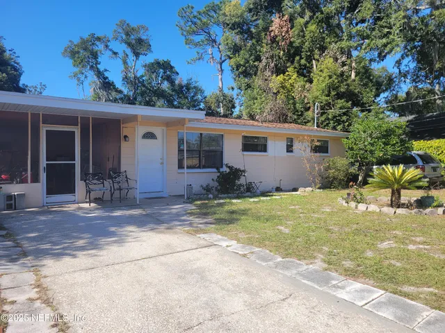 a view of a house with backyard and sitting area