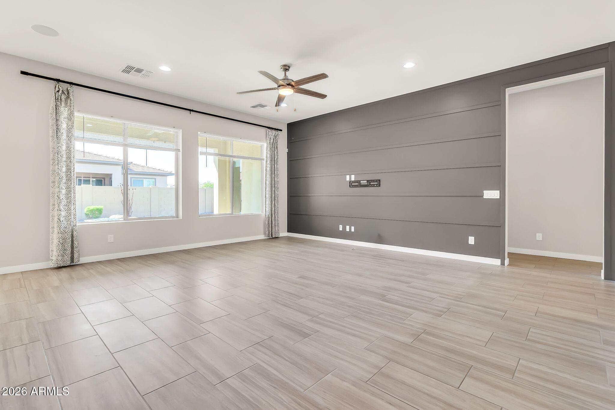 1441 East Powell Way Gilbert, AZ 85298 - Photo 10 of 63 a view of an empty room with a window and wooden floor
