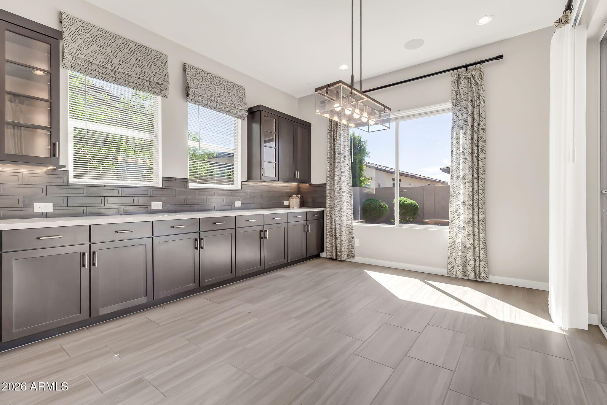 1441 East Powell Way Gilbert, AZ 85298 - Photo 19 of 63 a large kitchen with stainless steel appliances a large counter top a sink cabinets and wooden floor