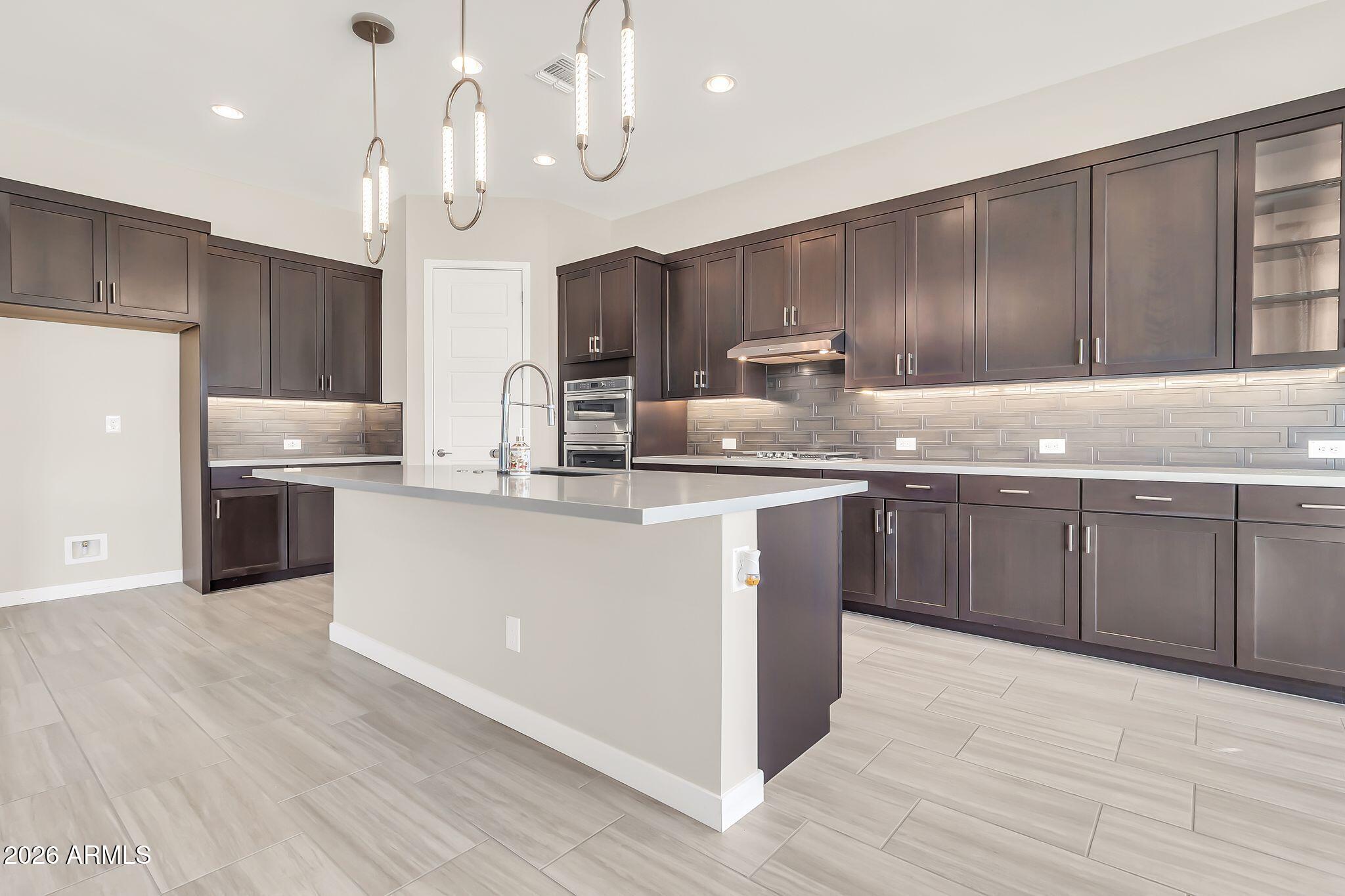 1441 East Powell Way Gilbert, AZ 85298 - Photo 22 of 63 a kitchen with kitchen island granite countertop a sink cabinets and wooden floor