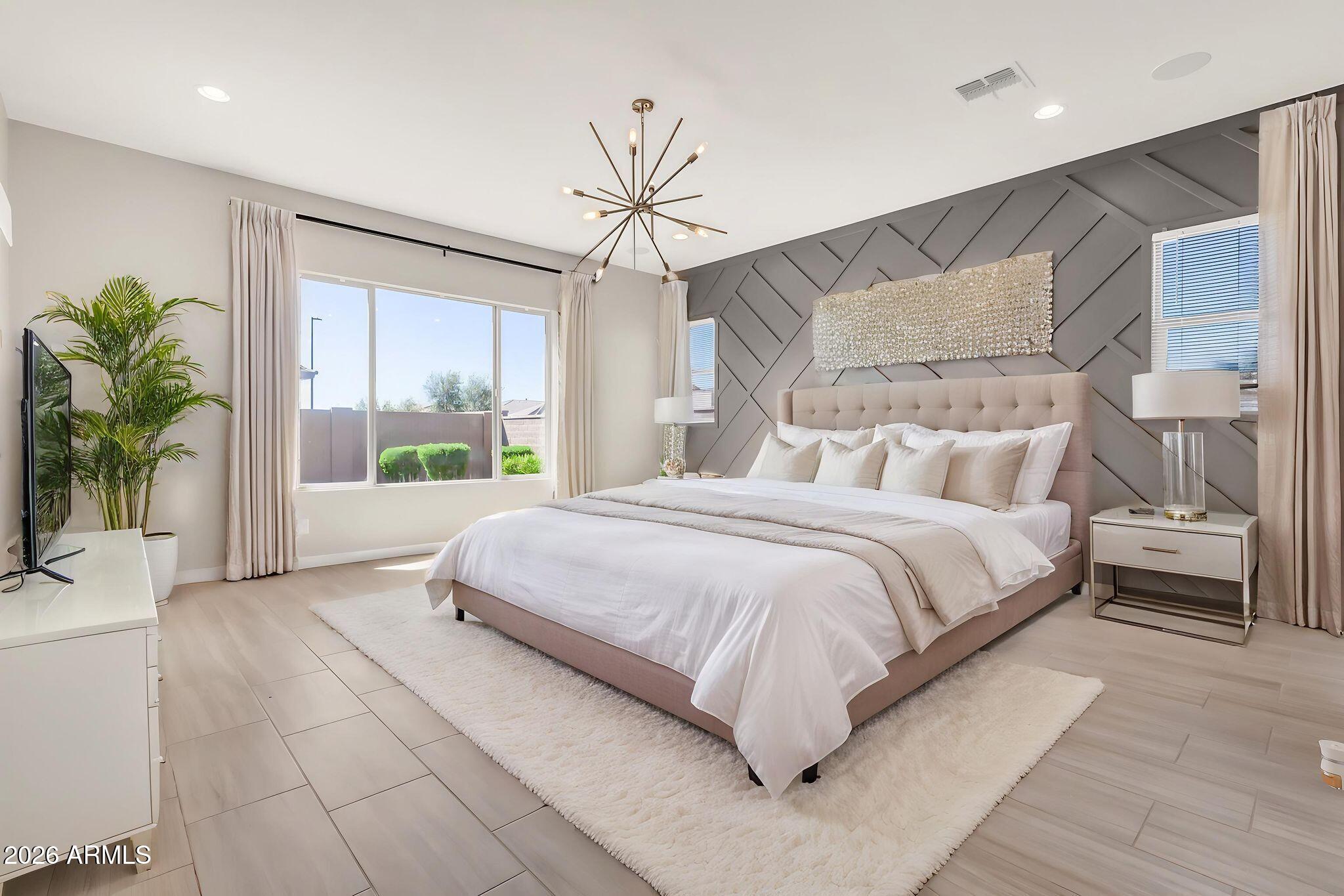 1441 East Powell Way Gilbert, AZ 85298 - Photo 23 of 63 a bedroom with a large bed and a chandelier
