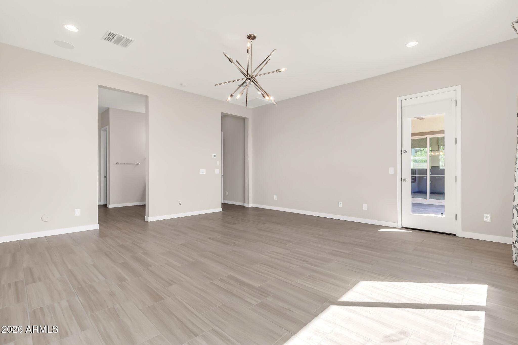 1441 East Powell Way Gilbert, AZ 85298 - Photo 25 of 63 a view of an empty room with wooden floor and a window