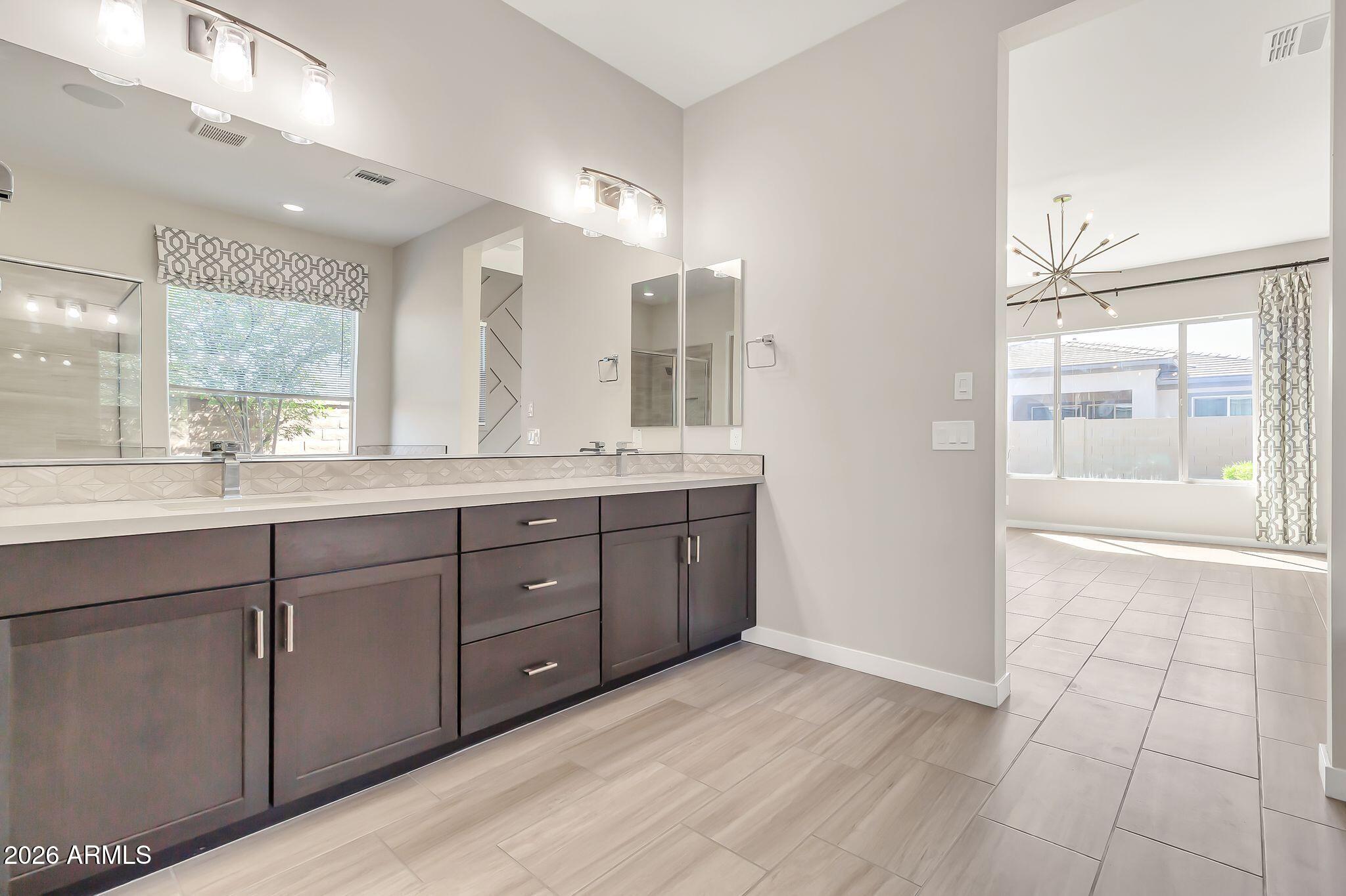 1441 East Powell Way Gilbert, AZ 85298 - Photo 29 of 63 a bathroom with a double vanity sink a mirror and a shower