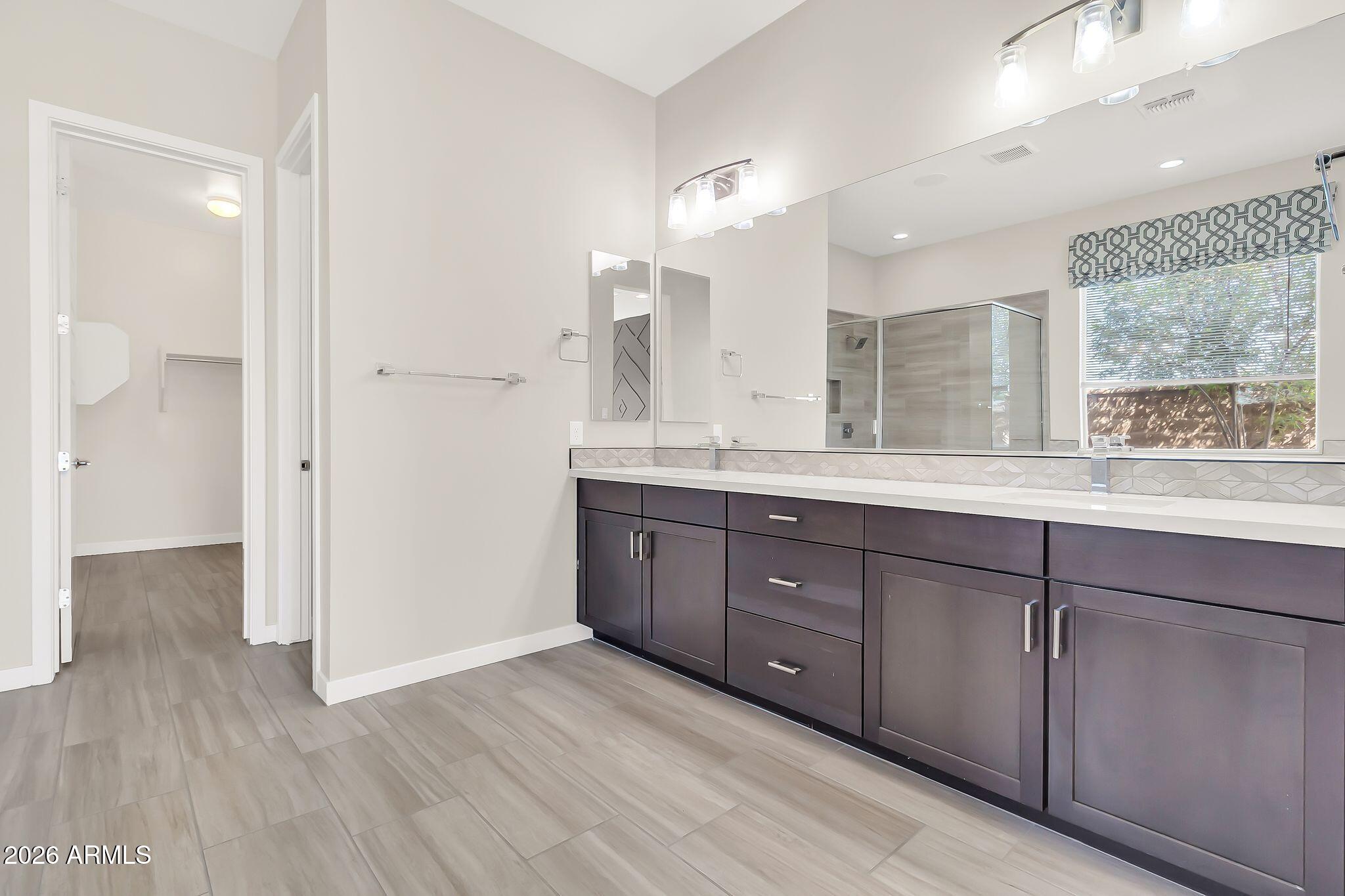 1441 East Powell Way Gilbert, AZ 85298 - Photo 30 of 63 a spacious bathroom with a granite countertop sink mirror and a shower