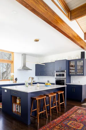a kitchen with stainless steel appliances a sink a stove a refrigerator cabinets and a dining table