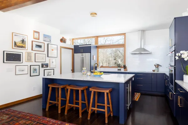 a kitchen with stainless steel appliances a table and chairs in it