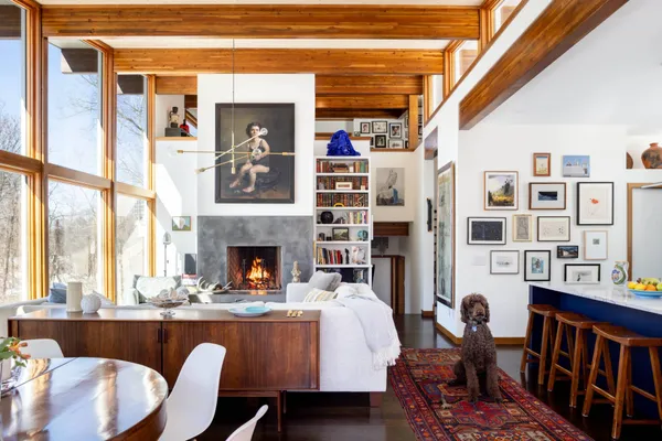 a living room with fireplace furniture and a large window