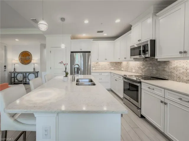 a kitchen with stainless steel appliances granite countertop a sink a stove and a microwave